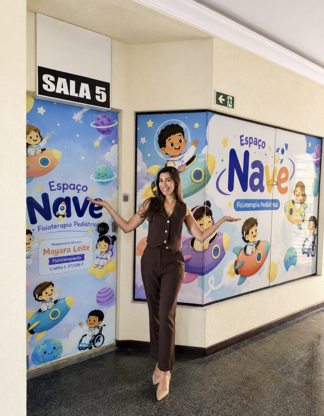 Mayara Leite na entrada do Espaço Nave, com a identidade visual na porta